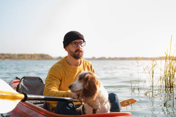 istock Man with a dog in a canoe on the lake. 1283546584