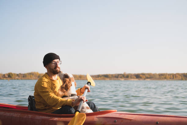 istock Man with a dog in a canoe on the lake. 1283546629