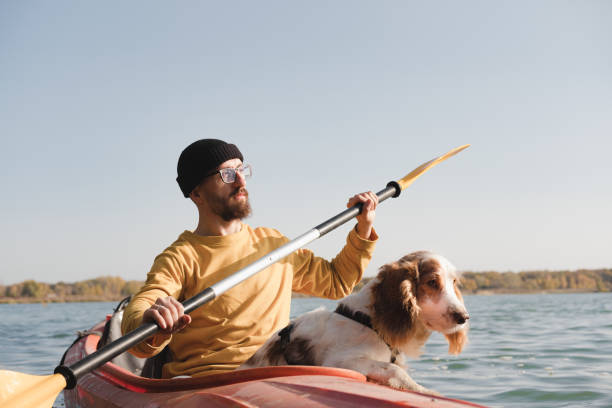 istock Kayaking with dogs: man rowing a boat on the lake with his spaniel. 1283546652