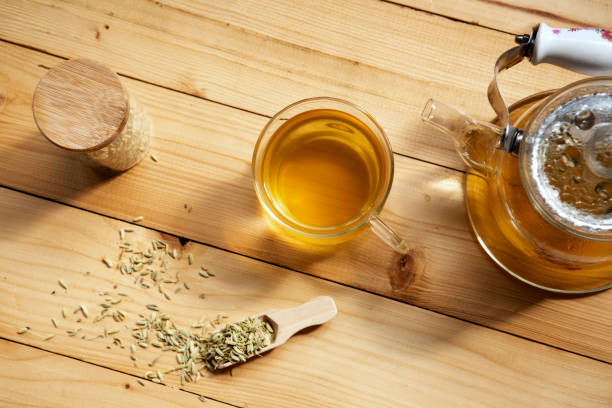 Herbal infusion fennel tea Herbal infusion fennel tea in glass cup and glass tea pot with dried fennel seeds in wooden shovel on table fennel stock pictures, royalty-free photos & images