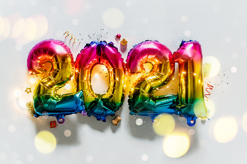 Rainbow colored Foil balloons in the form of numbers 2021. New year celebration. Holiday party decoration, flat lay
