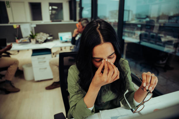 istock Stressed mixed race business woman scratching her dry eyes while meeting deadlines feeling stressed sitting in office 1283550165