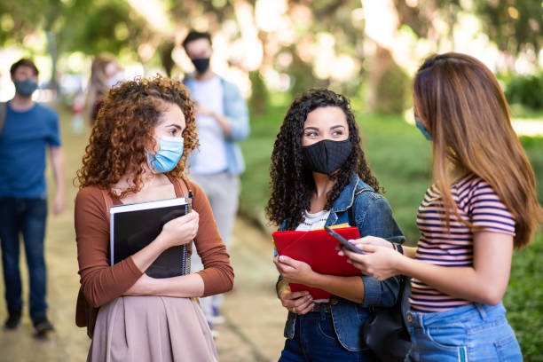 istock Small group of young students talking and wearing face protection mask at university 1283550978