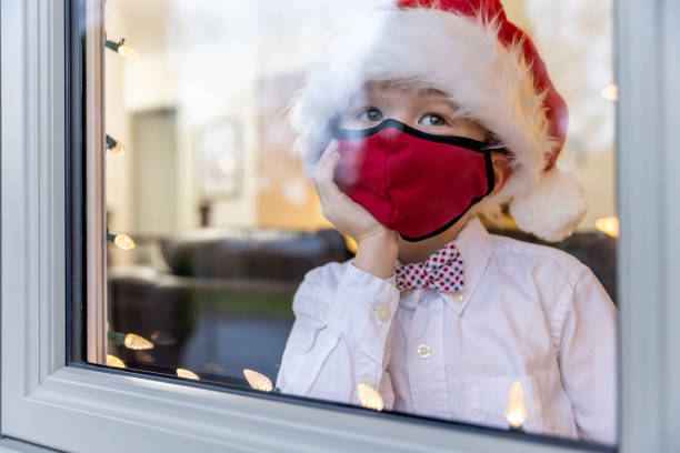 istock Young Boy Looking Through home window during the Covid-19 Pandemic 1283551263
