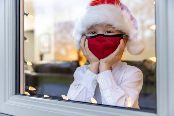 istock Young Boy Looking Through home window during the Covid-19 Pandemic 1283551337