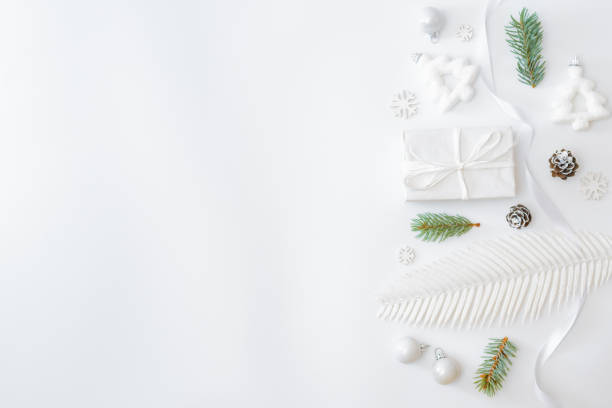 istock Flat lay frame with fir branches, christmas baubles decoration and gift box on a white background 1283551392