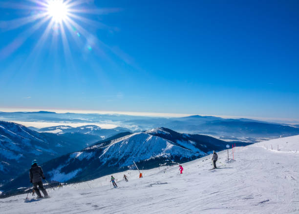 istock Winter Sun over Ski Run and Mountain Peaks 1283551735