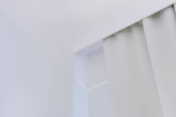 istock Interior details close up. White wall, ceiling, cornice niche, curtains on the window 1283555012