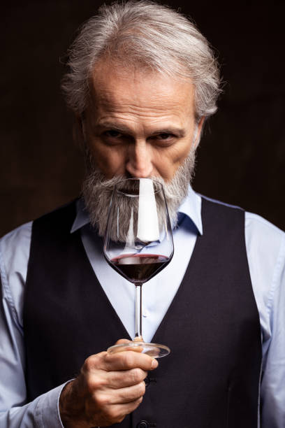 Senior sommelier tasting red wine Studio shot of winemaker or sommelier tasting wine sommelier photos stock pictures, royalty-free photos & images
