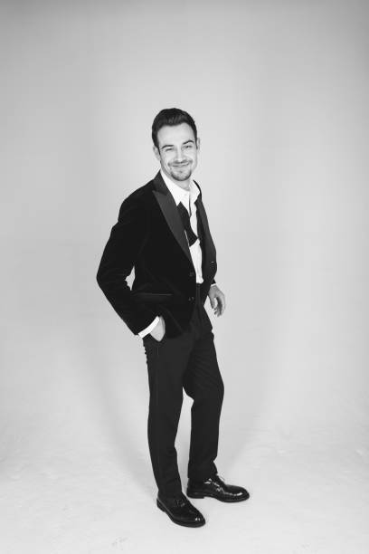 Studio portrait of a young man in a tuxedo against plain studio background