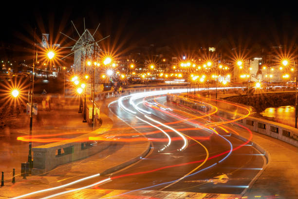 Long exposure image of a city during the rush hour in the dark. Car light trails, and street lamps.