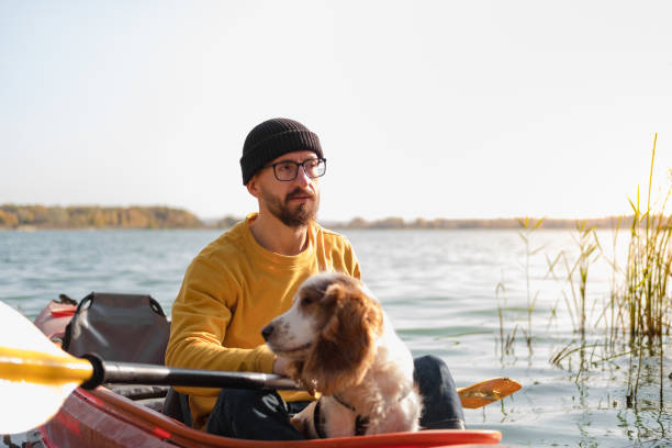 istock Man with a dog in a canoe on the lake. 1283563531