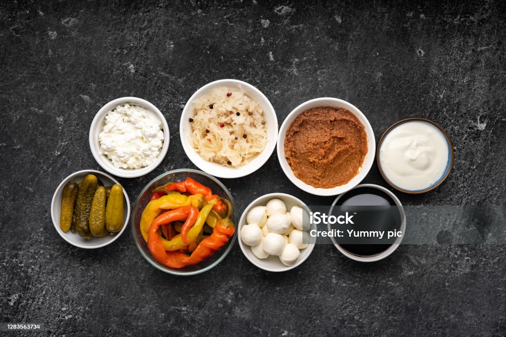 Many plates with fermented foods healthy for immunity and gut Top view of many plates with fermented organic foods rich of healthy bacteria. Probiotics. Black background. Healthy diet concept for immunity and human microbiome Healthy Eating Stock Photo