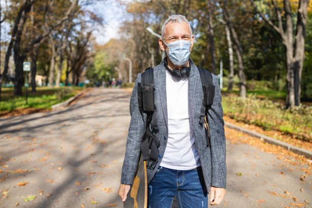 istock Cheerful man walking in sunny park during quarantine 1283563890