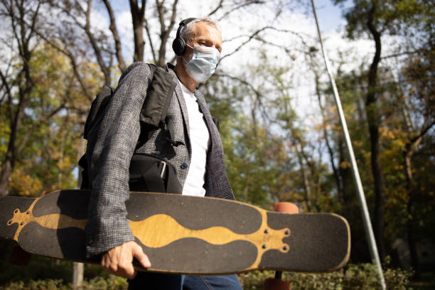 istock Mature active man walking with skateboard in mask 1283563891