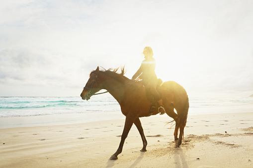 Woman out in nature at one with her horse.