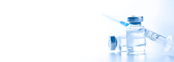 istock Medical syringe with a needle and a bollte with vaccine. 1283564313