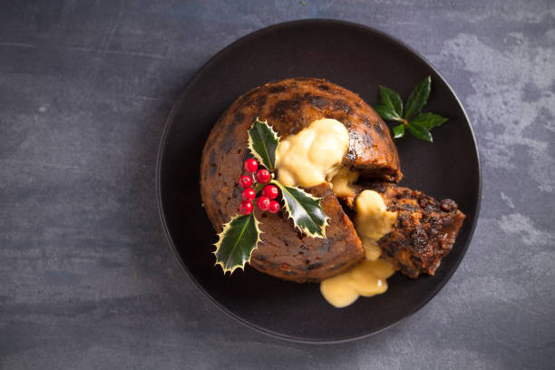 istock Richly spiced Christmas pudding cake with custard and Christmas decorations 1283567745