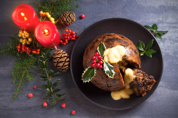 Richly spiced Christmas pudding cake with custard and Christmas decorations