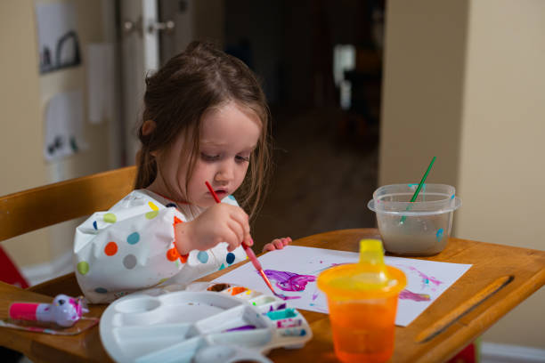 istock Three Year Old Girl Paints in her Kitchen 1283568041