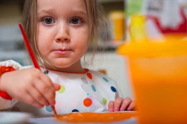 istock Three Year Old Girl Paints in her Kitchen 1283568050