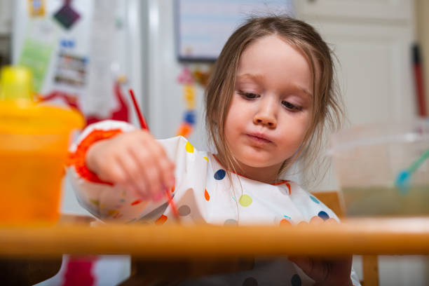 istock Three Year Old Girl Paints in her Kitchen 1283568087