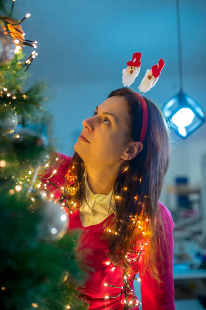 istock Young girl decorating christmas tree at home 1283569143