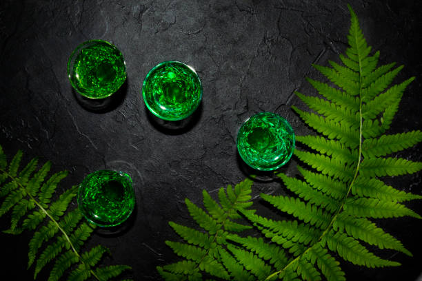 Strong alcohol. shot glasses with absinthe. Dark stone background stock photo