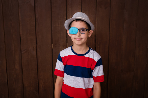Portrait of boy in glasses with patch. Eye patch for glasses t treat lazy eye, amblyopia, strabismus.