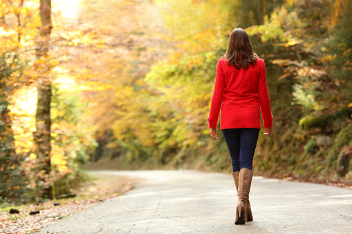 Back view of fashion woman in red walking in autumn