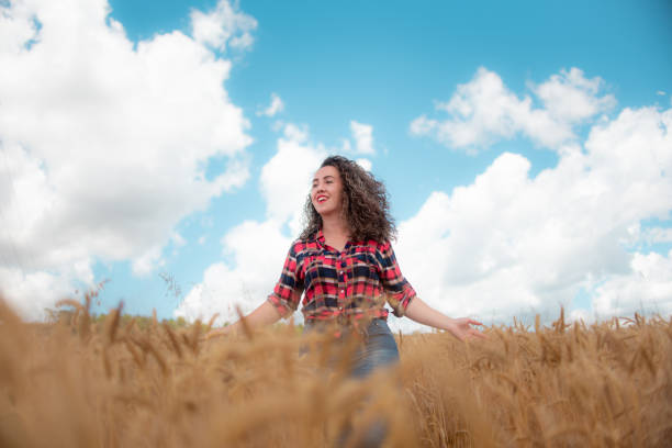 Girl holding heart-shape symbol for love in a wheat field.