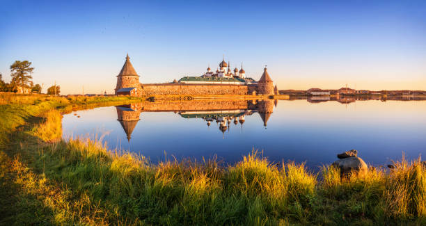 istock Mirror reflections of the Solovetsky Monastery and green grass 1283572936