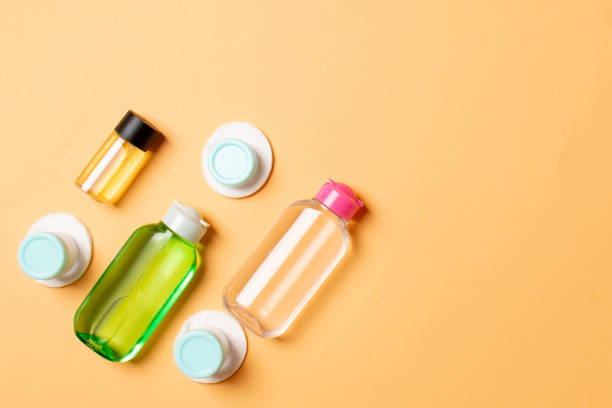 istock Group of small bottles for travelling on colored background. Copy space for your ideas. Flat lay composition of cosmetic products. Top view of cream containers with cotton pads 1283576306