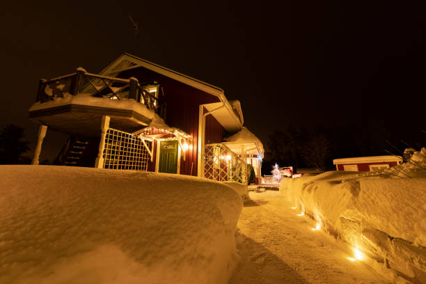 istock Typical Swedish red wooden house with big balcony, fresh just cleaned from snow walk path, decoration lights and real Christmas Tree stands on the terrace. Much snow at Christmas, Northern Sweden 1283577510