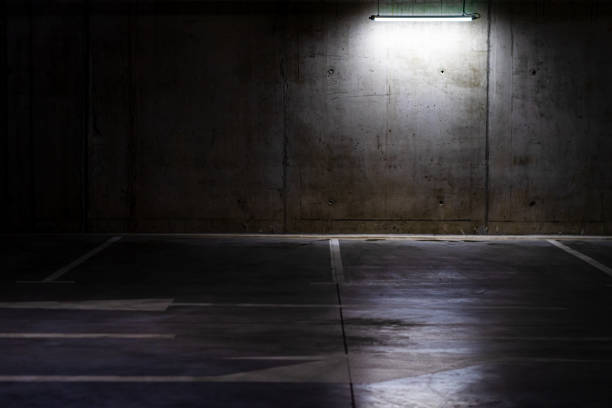 istock Empty parking lot with overhead dim light, underground parking garage. 1283577689