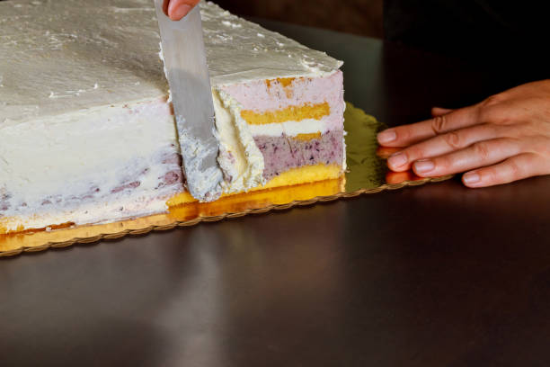 istock Woman cover with icing festive cake. Making layer sponge cake. 1283577796
