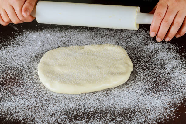istock Woman rolling with pin royal icing for cake decorating. 1283577806