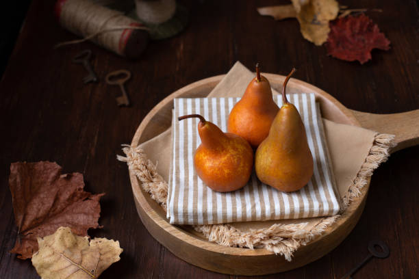 istock Three Fresh Pears on a Wooden Tray in a Rustic Tabletop Setting 1283577872