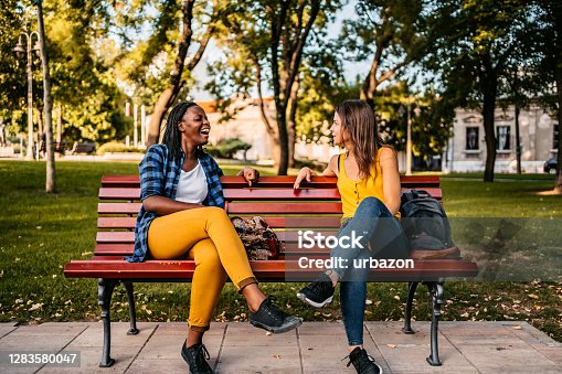 istock Friends talking on bench 1283580047
