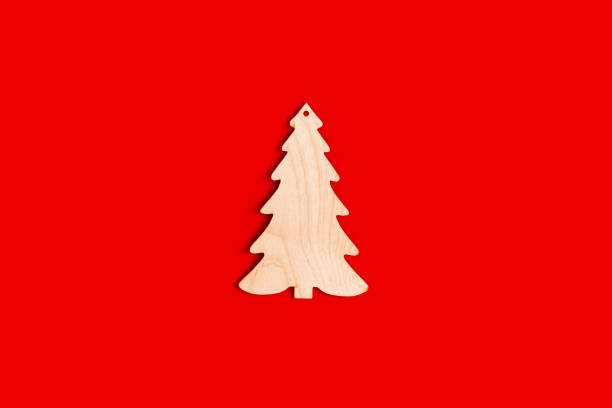 istock Flat natural unpainted wooden spruce shape on red background. 1283580049