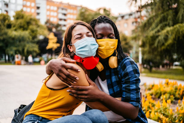 istock Two friends with face masks embracing 1283580406