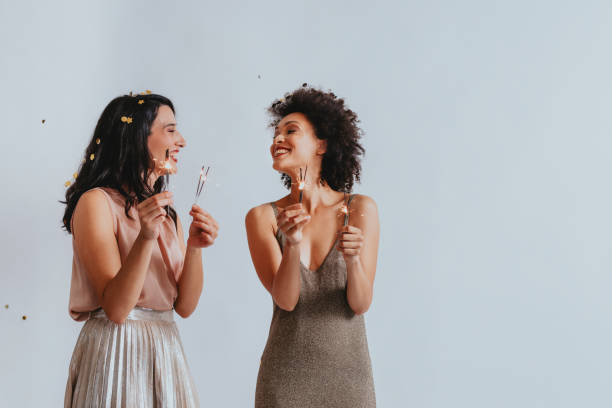 Studio Shot of Two Happy Women Having Fun Playing With Sparklers (Copy Space)