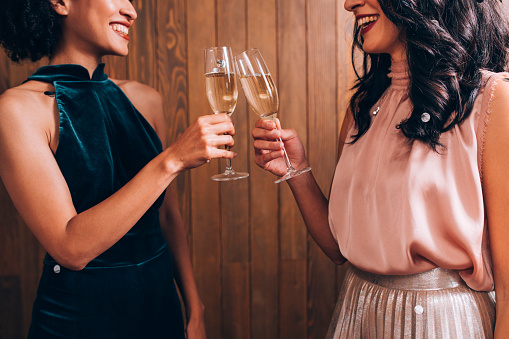 Party time: two elegant young women drinking champagne to celebrate together.