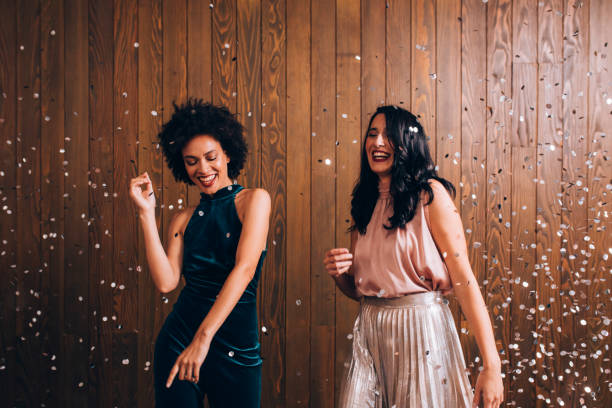 istock Party Time: Two Beautiful Women Dancing in Confetti Rain, Feeling Festive Concept 1283586133