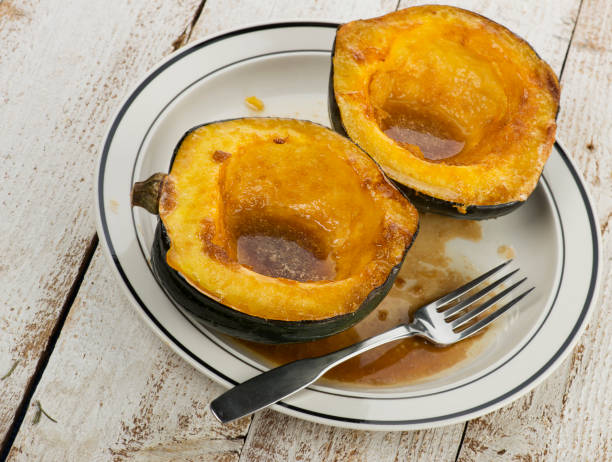 acorn squash gekocht mit braunem zucker und butter - acorn stock-fotos und bilder