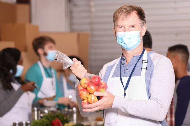 istock Multi-ethnic group of volunteers work at soup kitchen. 1283590614