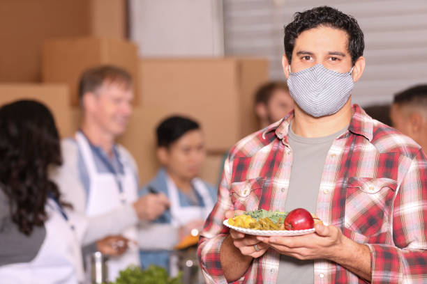 istock Multi-ethnic group of volunteers work at soup kitchen. 1283590620