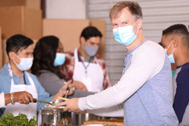 istock Multi-ethnic group of volunteers work at soup kitchen. 1283591184