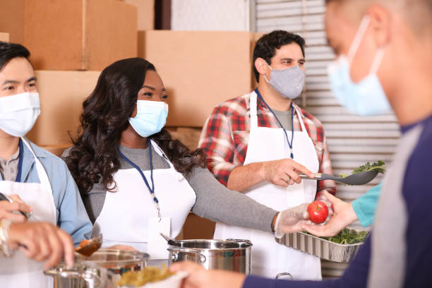istock Multi-ethnic group of volunteers work at soup kitchen. 1283591226