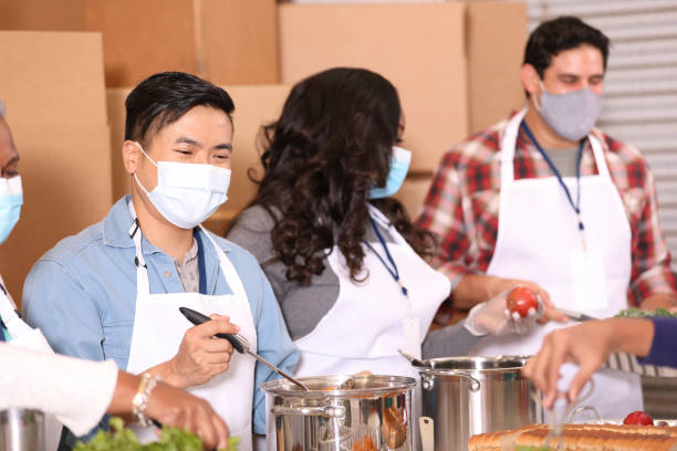 istock Multi-ethnic group of volunteers work at soup kitchen. 1283591244